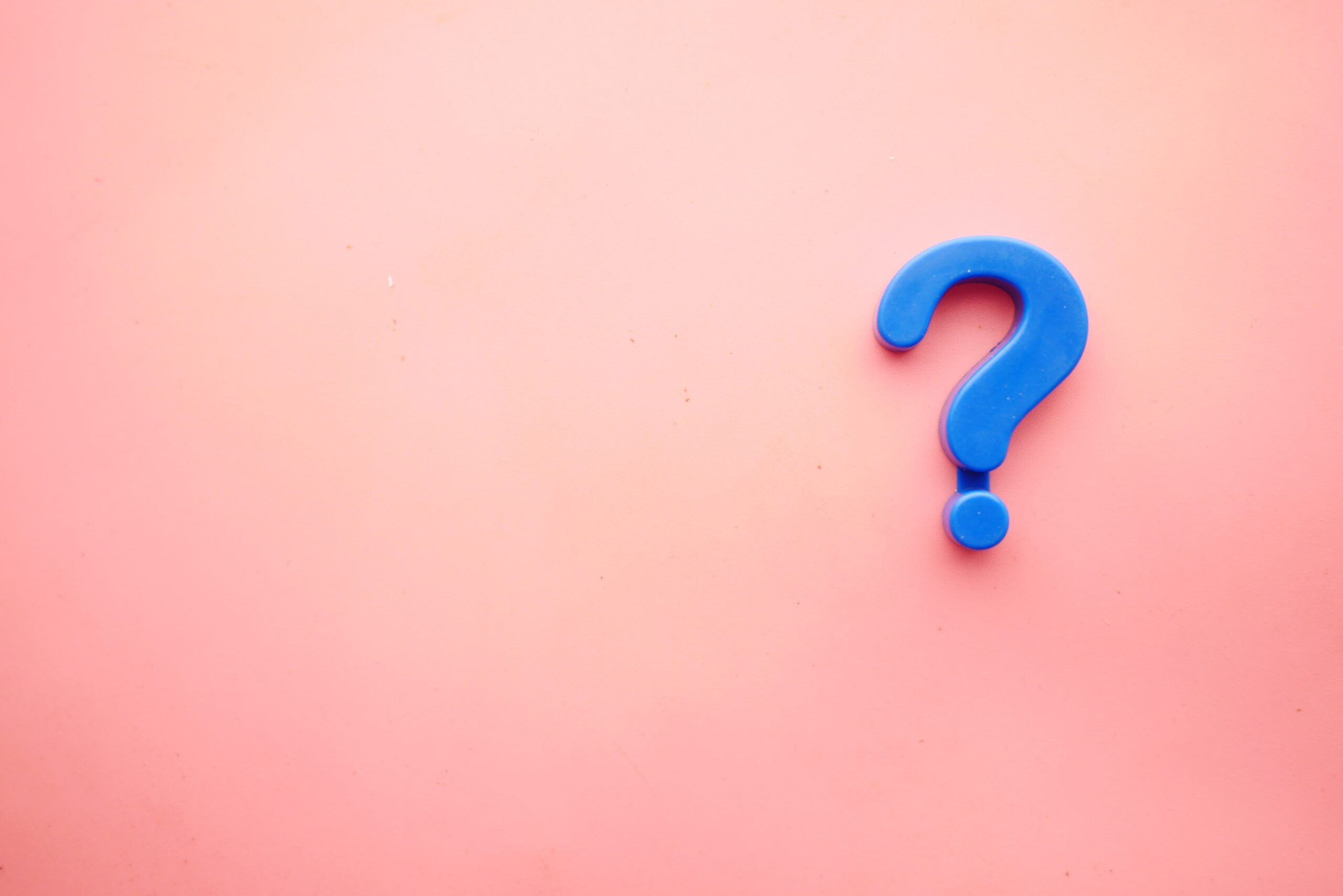 A blue question mark symbol on a pink background